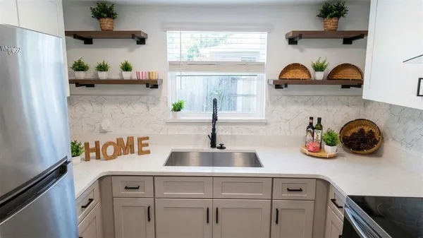 a kitchen with white cabinets and window