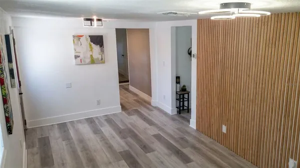 a view of a hallway with wooden floor and closet