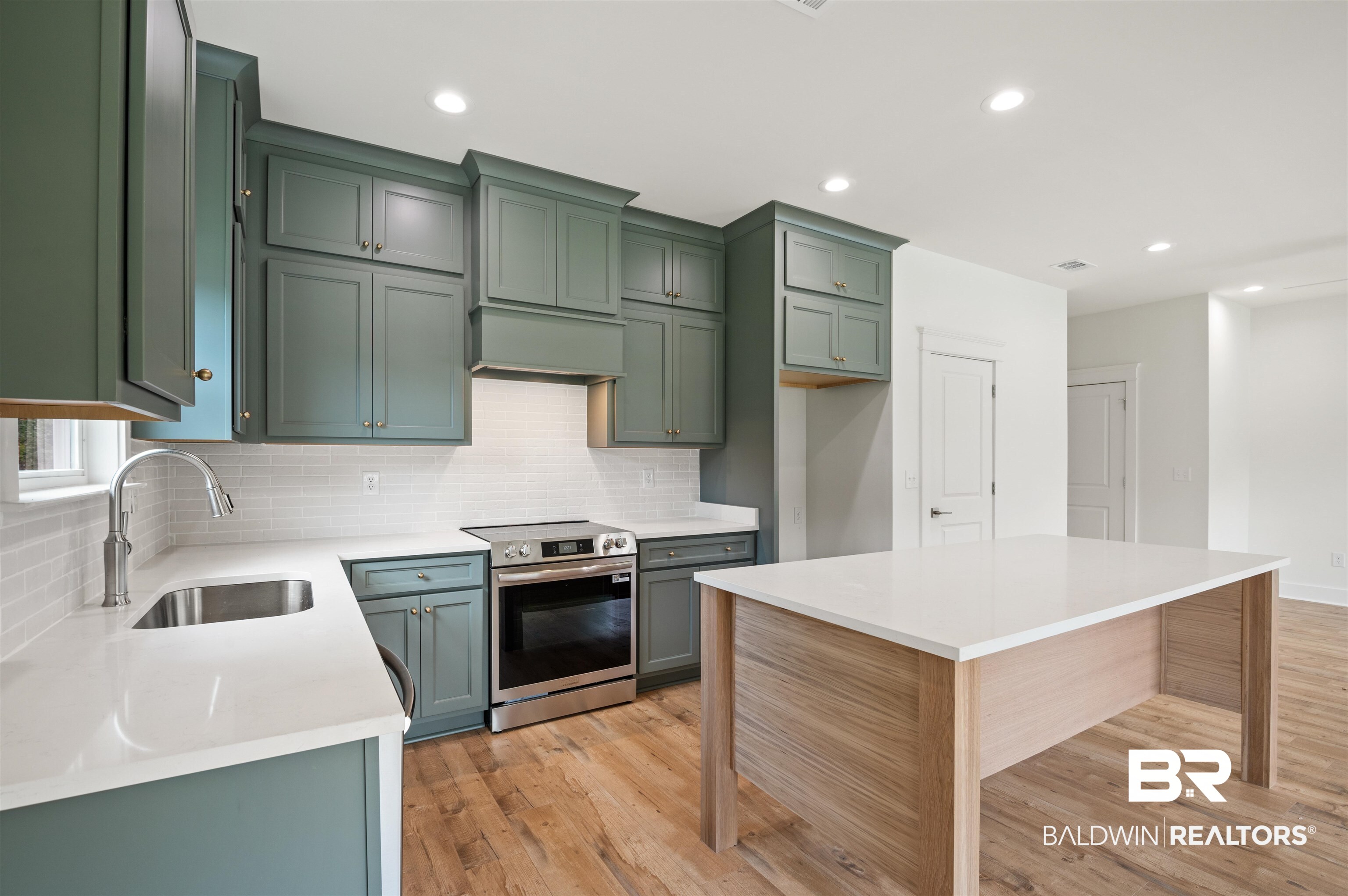 657 Island Way Gulf Shores, AL 36542 - Photo 9 of 59 Kitchen with stainless steel range with electric stovetop, a sink, decorative backsplash, light wood-style flooring, and light countertops