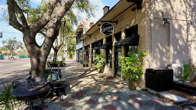 a view of a brick house with large windows and a large tree