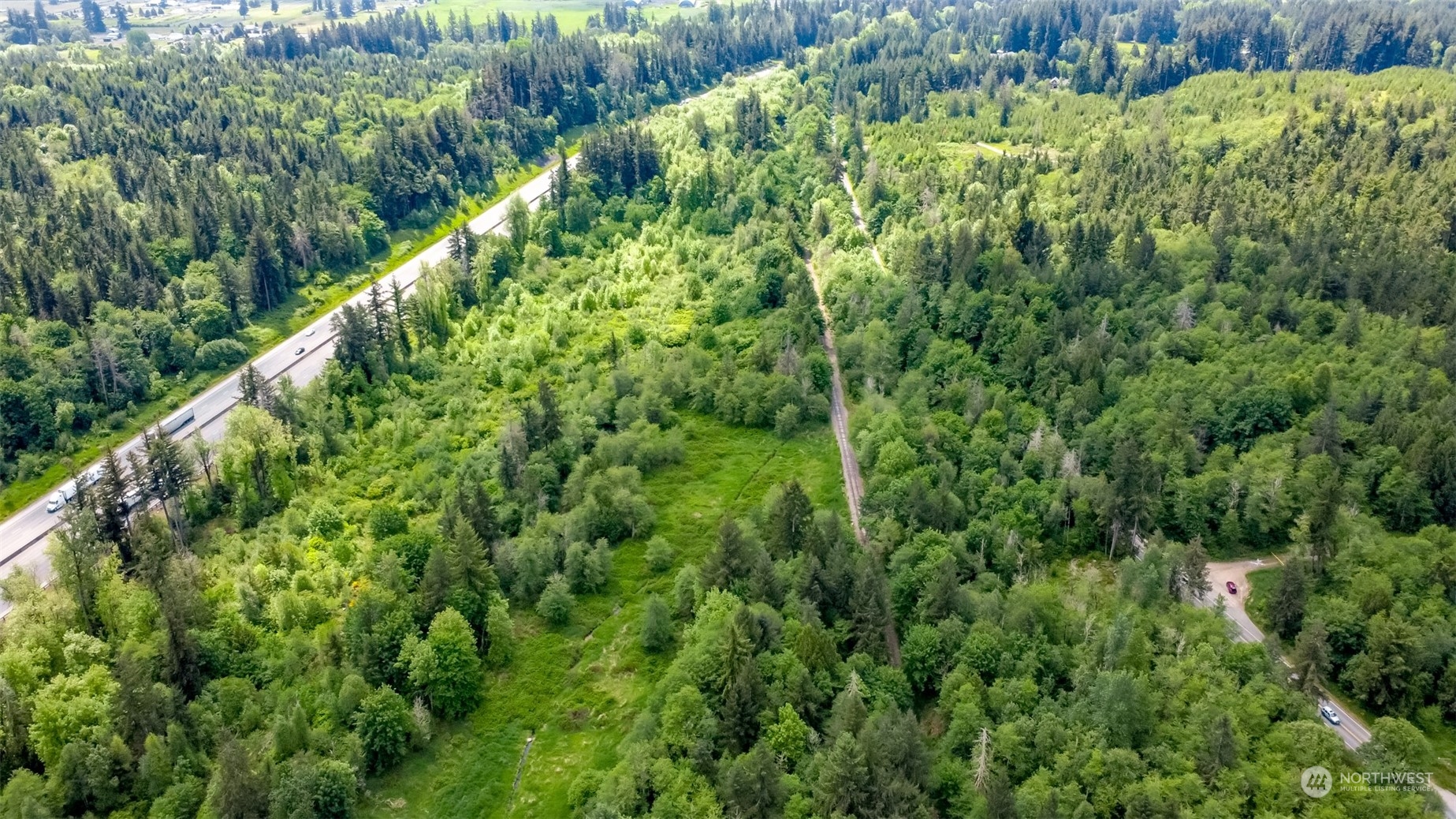15345 Case Road Southwest Rochester, WA 98579 - Photo 16 of 40 a view of a lush green forest with lawn chairs and a wooden fence