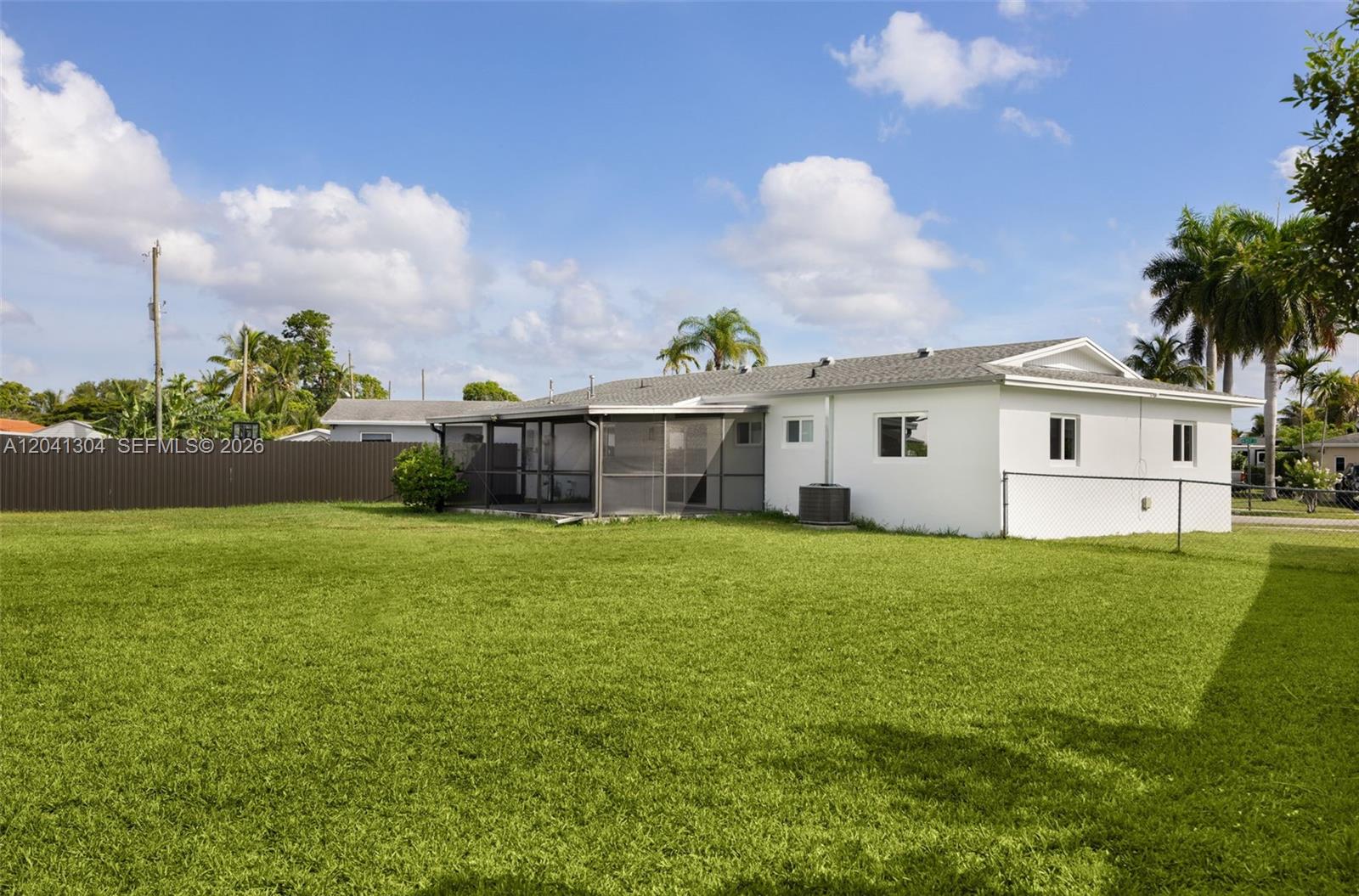 10340 Southwest 157th Street Miami, FL 33157 - Photo 20 of 24 Backyard – Spacious backyard with an expansive lawn and fenced perimeter, offering exceptional outdoor versatility. Plenty of room to enjoy outdoor activities and entertaining.