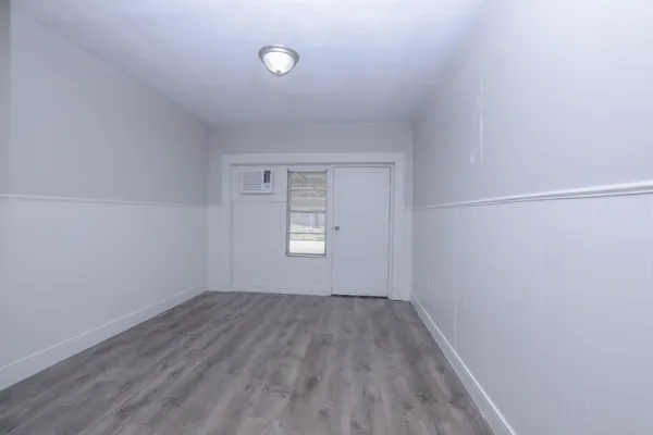 a view of an empty room with wooden floor
