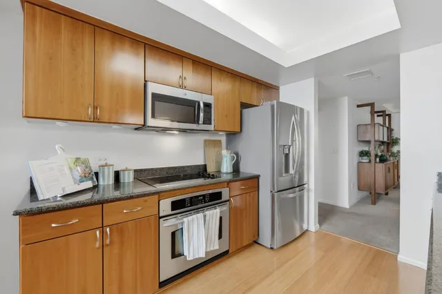 a kitchen with granite countertop wooden cabinets and stainless steel appliances