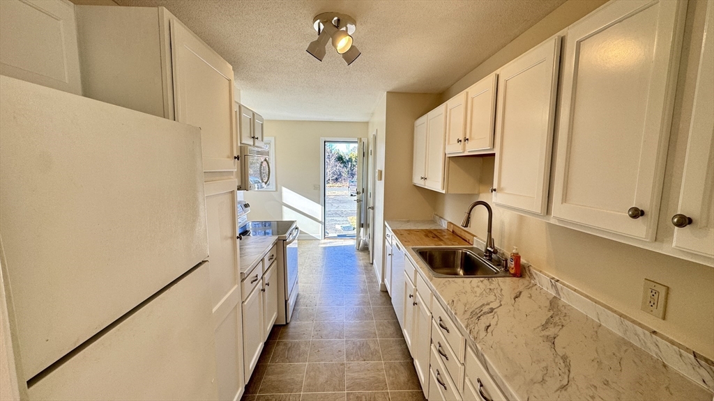 16 Collins Street, Unit 16 Chicopee, MA 01022 - Photo 4 of 31 a view of a kitchen with a sink and cabinets