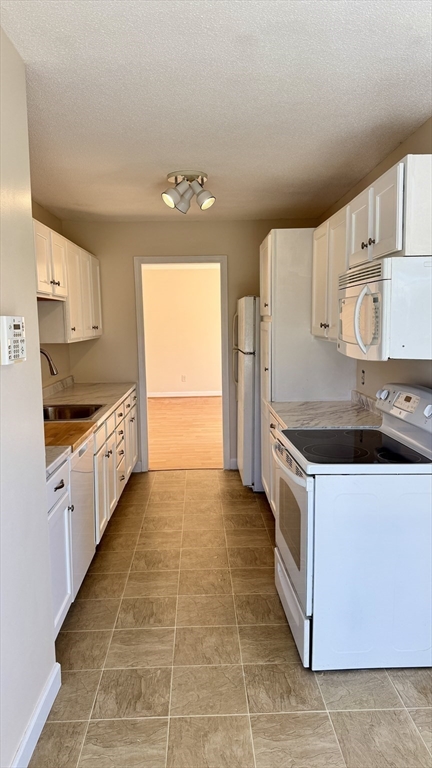 16 Collins Street, Unit 16 Chicopee, MA 01022 - Photo 8 of 31 a kitchen with granite countertop a sink a stove and refrigerator