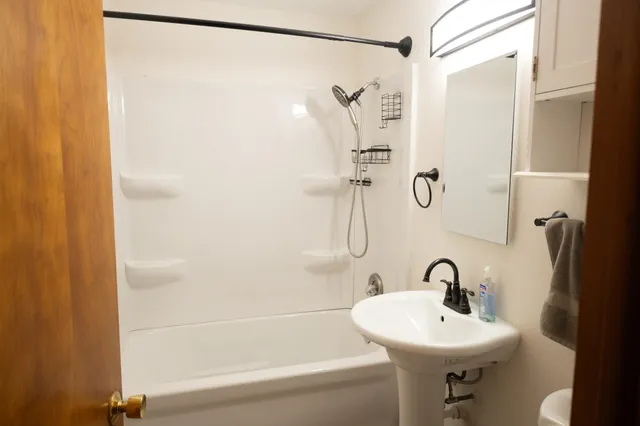 a bathroom with a sink a mirror and a shower