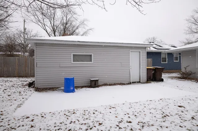 a backyard of a house with barbeque oven and wooden fence