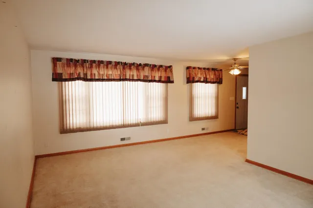 an empty room with windows and closet