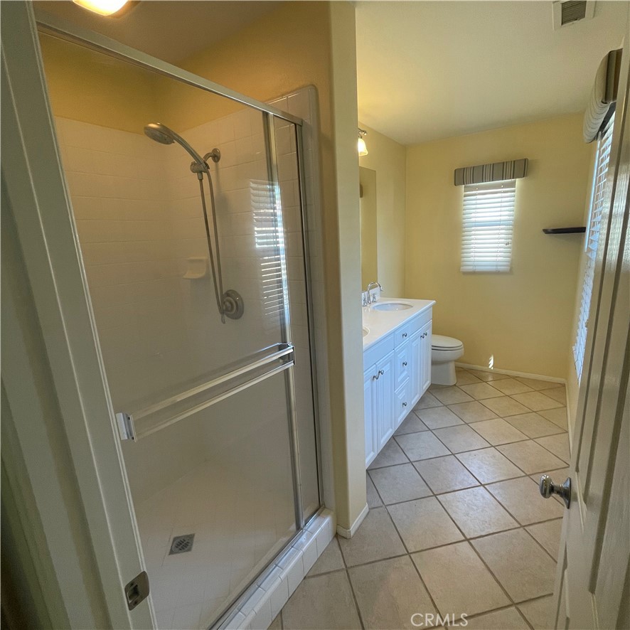 103 Windchime Irvine, CA 92603 - Photo 9 of 16 a bathroom with a granite countertop sink a mirror and a shower