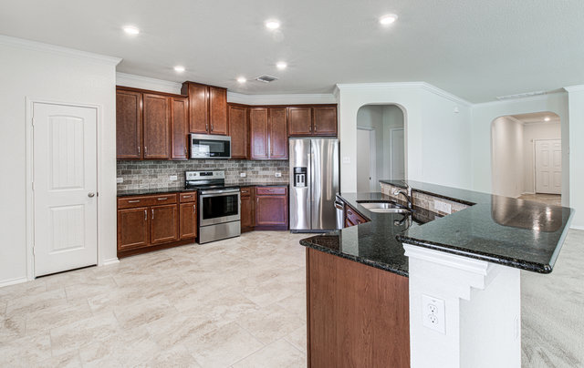 1237 Volente Lane Leander, TX 78641 - Photo 4 of 22 Culinary aspirations come alive in this kitchen, featuring ample storage, stainless appliances, and granite island.
