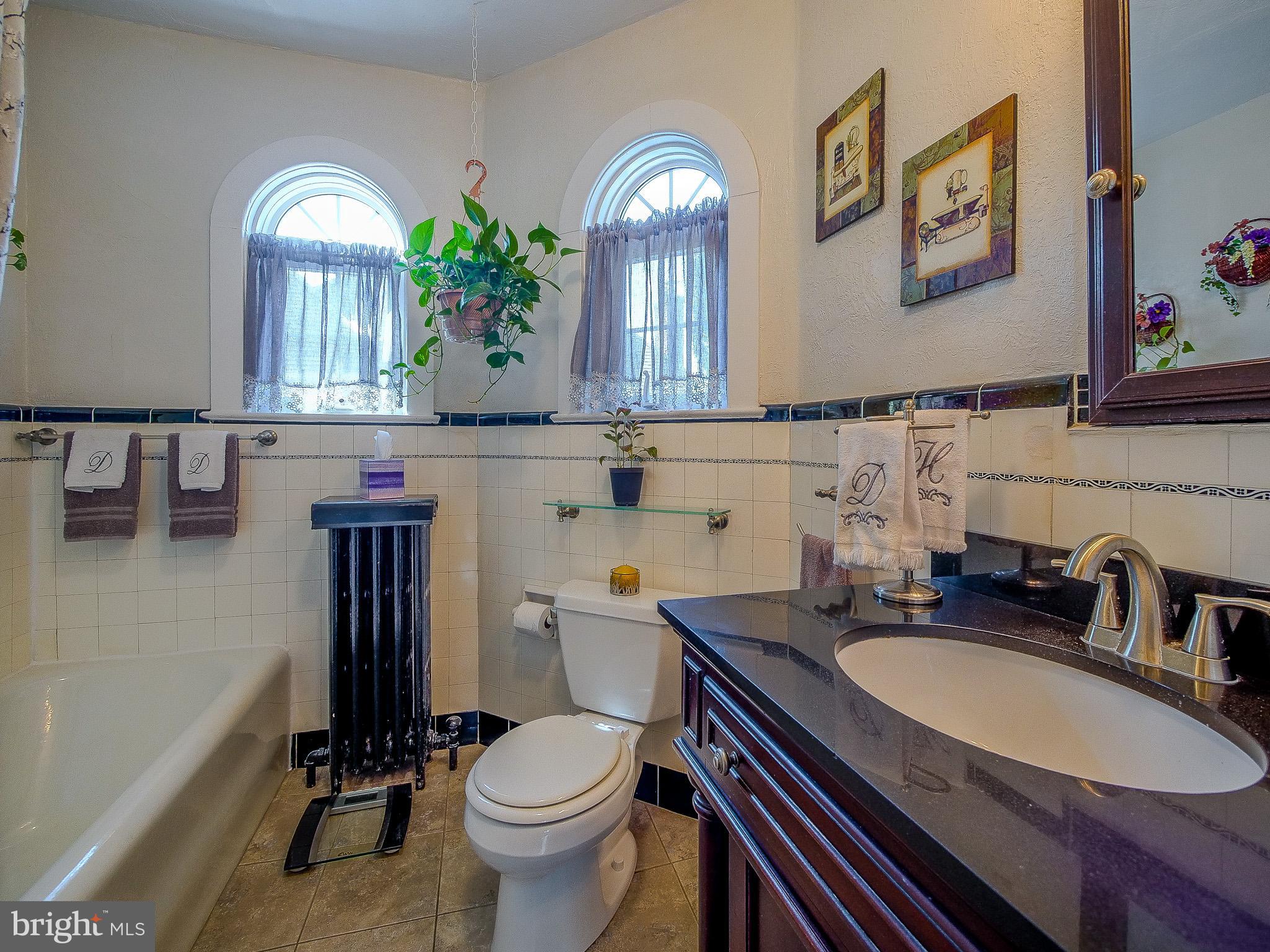 7205 Wayne Avenue Upper Darby, PA 19082 - Photo 57 of 84 a bathroom with a granite countertop toilet a sink and a mirror