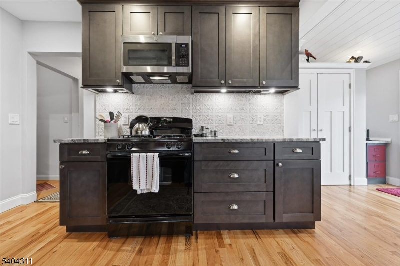 24 Ozone Avenue Cedar Grove, NJ 07009 - Photo 11 of 36 a kitchen with wooden cabinets and a stove top oven