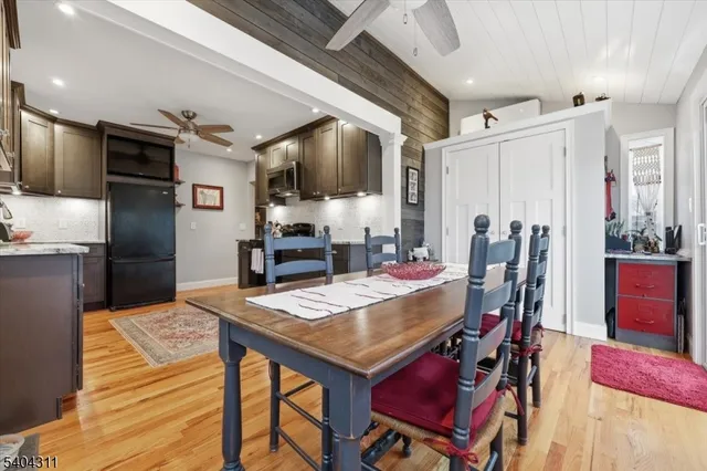 a kitchen with stainless steel appliances kitchen island granite countertop a table chairs and a refrigerator