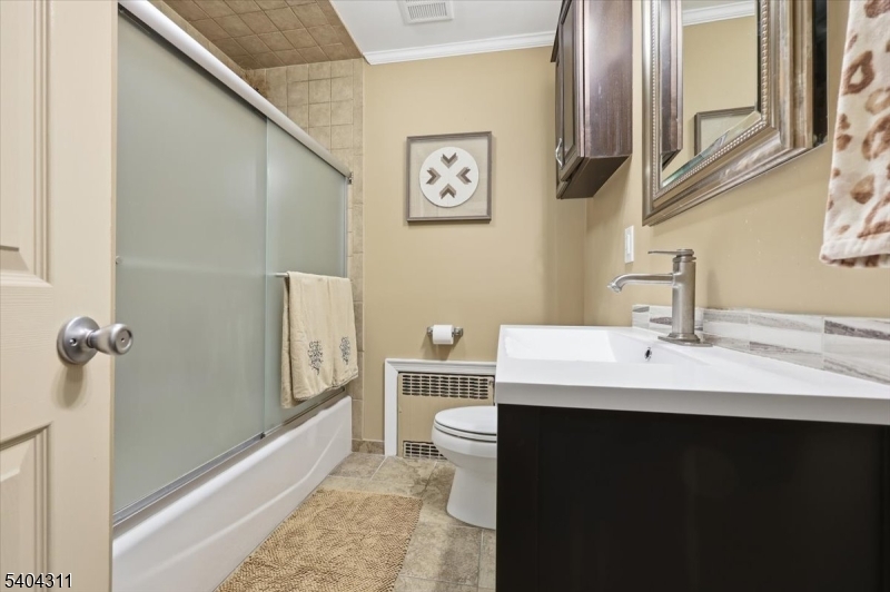 24 Ozone Avenue Cedar Grove, NJ 07009 - Photo 24 of 36 a bathroom with a sink a toilet a mirror and shower
