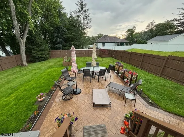 a view of a patio with couches table and chairs and garden