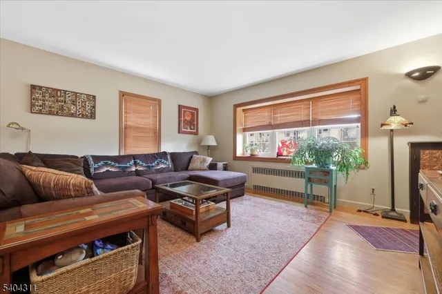 a living room with furniture a flat screen tv and a floor to ceiling window