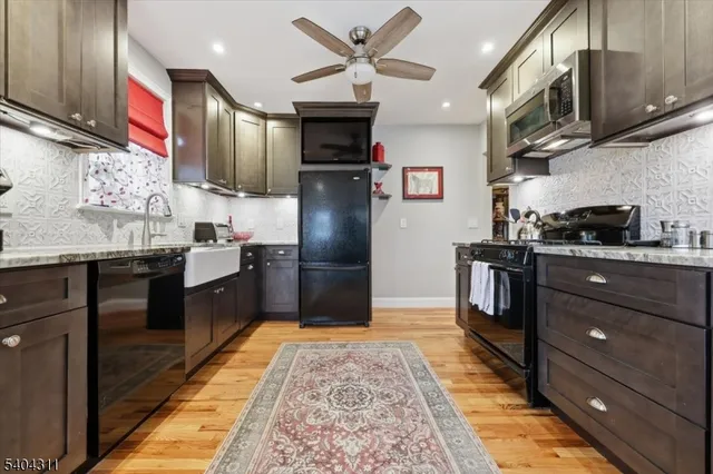 a kitchen with stainless steel appliances granite countertop a refrigerator a stove and a sink