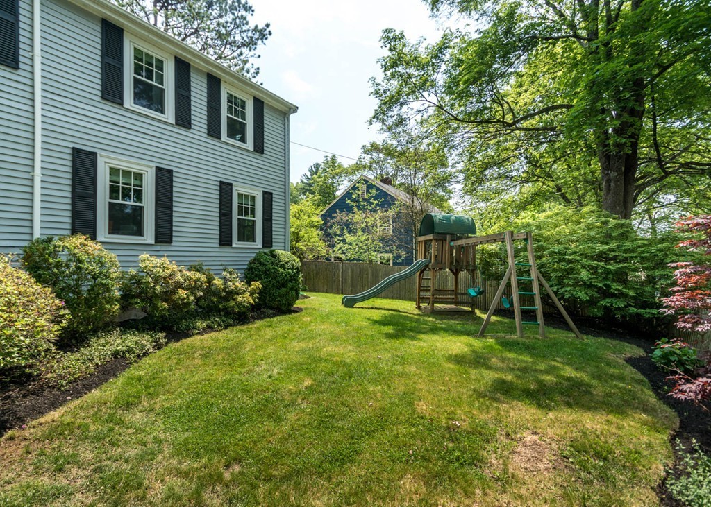 8 Nobscot Road Wellesley, MA 02482 - Photo 24 of 28 a view of a backyard with plants and a bench