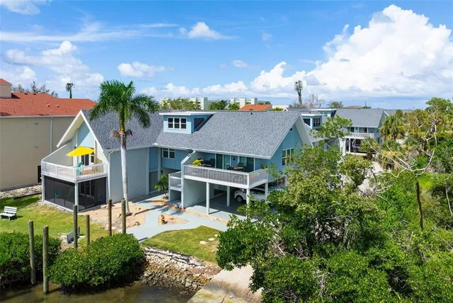 aerial view of a house with swimming pool and trees in the background