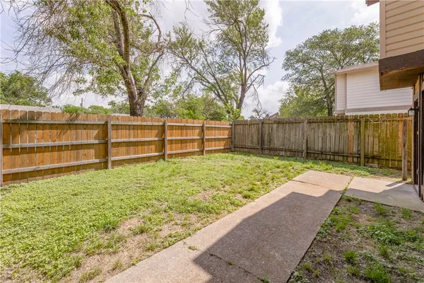 a view of backyard with wooden fence