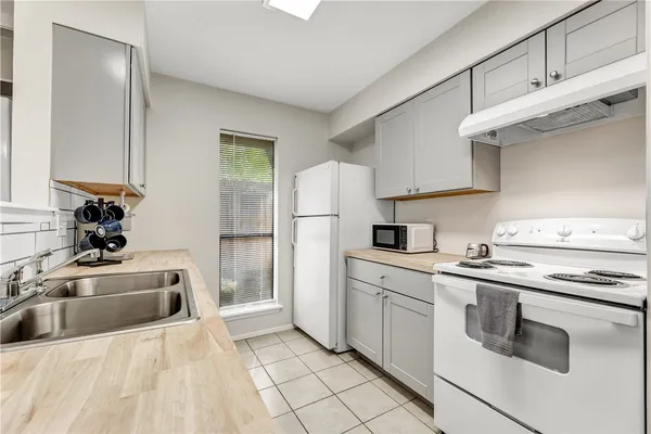 a kitchen with stainless steel appliances granite countertop a sink and a refrigerator