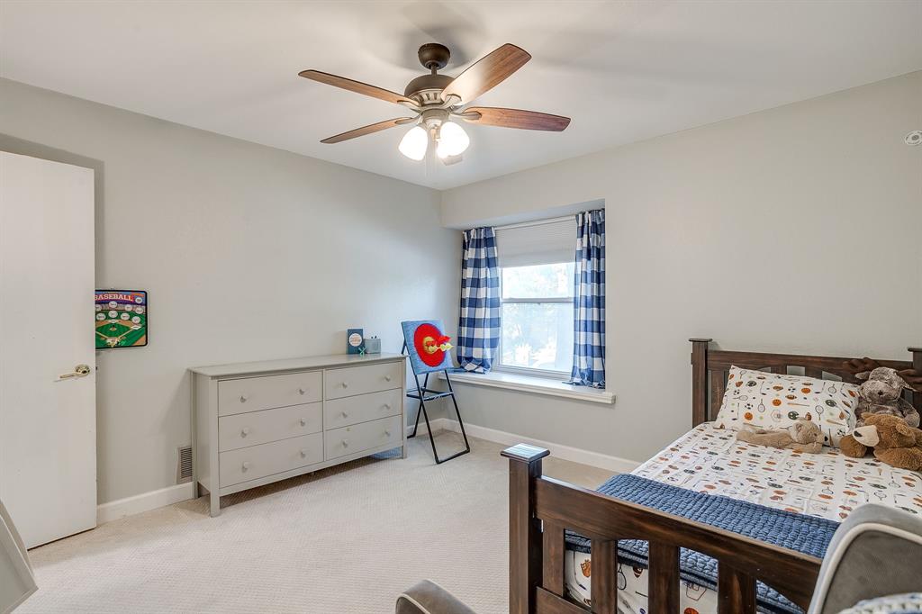 1804 Longbranch Court Arlington, TX 76012 - Photo 22 of 33 a bedroom with a bed and a chandelier