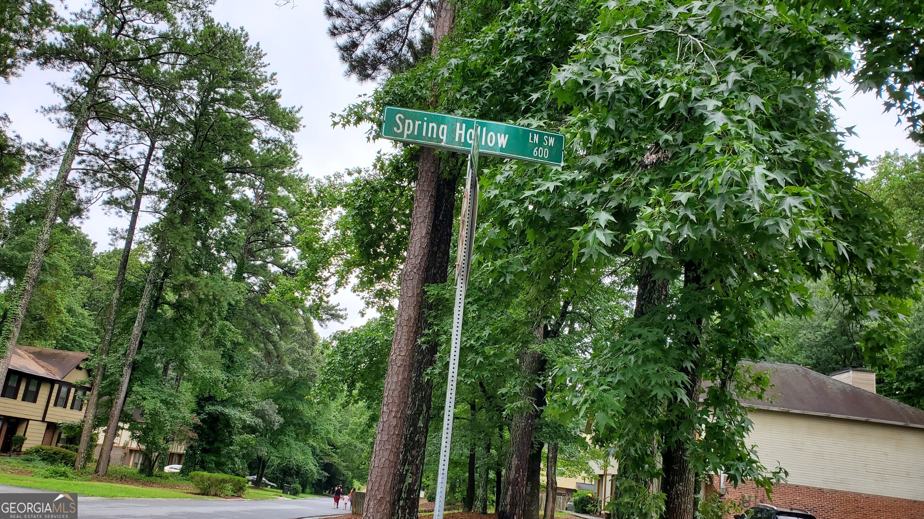 701 Springhollow Lane Southwest Marietta, GA 30008 - Photo 3 of 4 a view of a street with plants and large trees