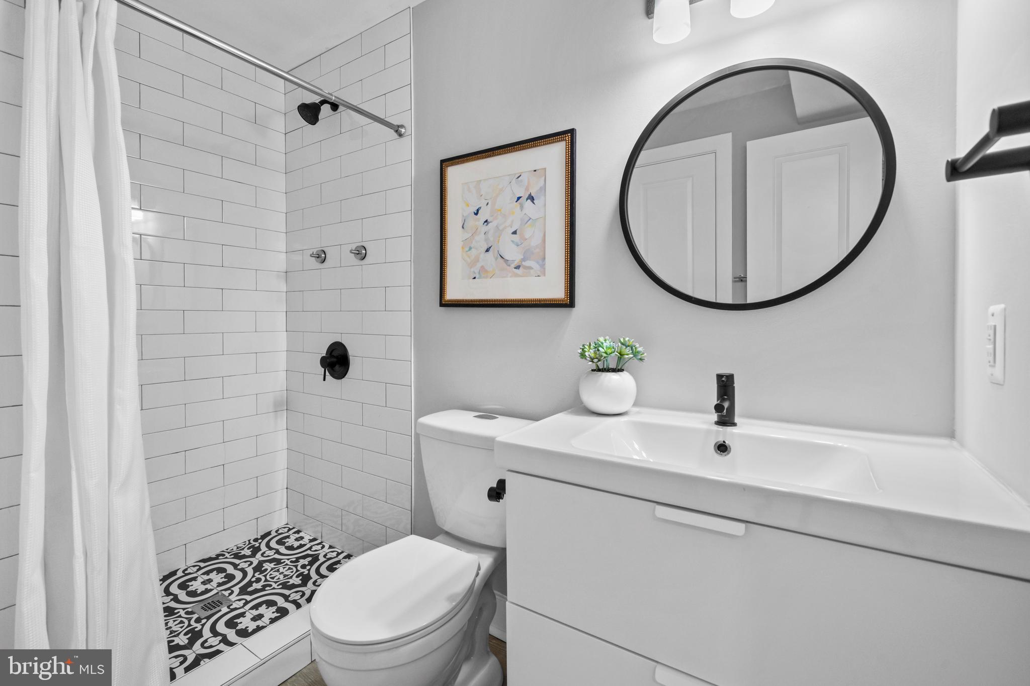 1718 1st Street Northwest, Unit 8 Washington, DC 20001 - Photo 11 of 25 a bathroom with a sink a mirror a toilet and a shower