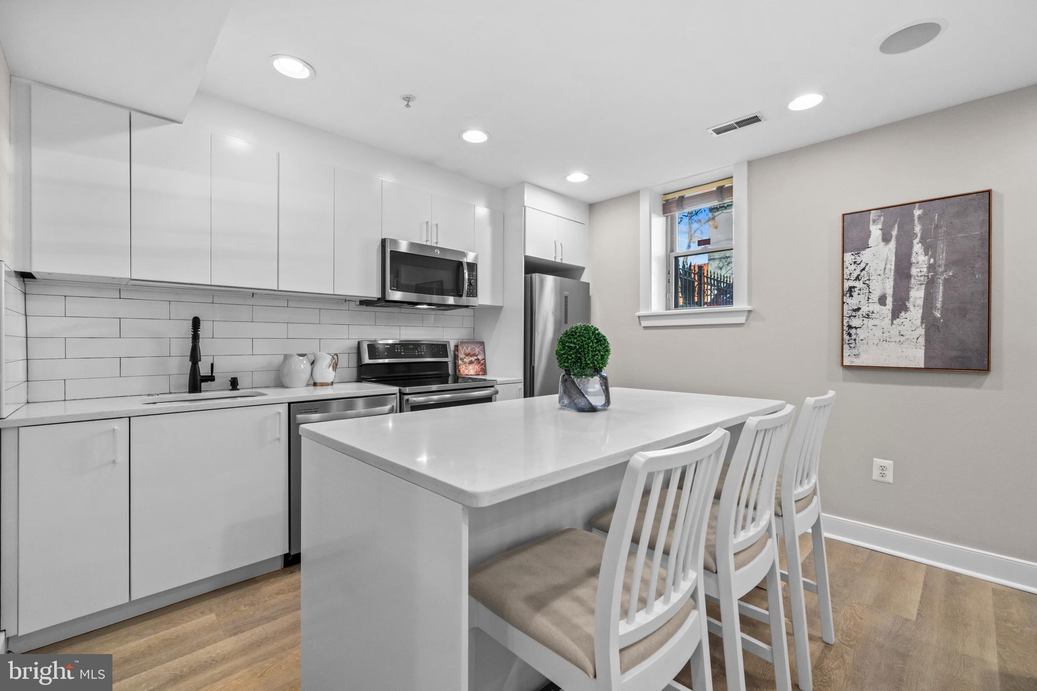 1718 1st Street Northwest, Unit 8 Washington, DC 20001 - Photo 4 of 25 a kitchen with a white cabinets and chairs in it