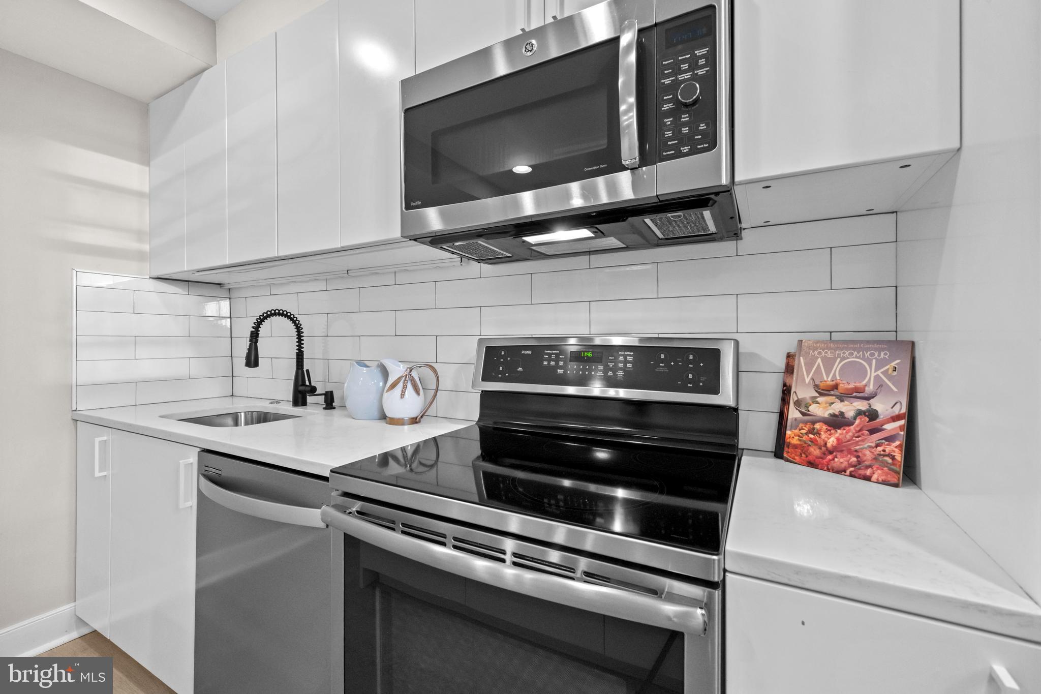 1718 1st Street Northwest, Unit 8 Washington, DC 20001 - Photo 5 of 25 a kitchen with stainless steel appliances a stove and a microwave