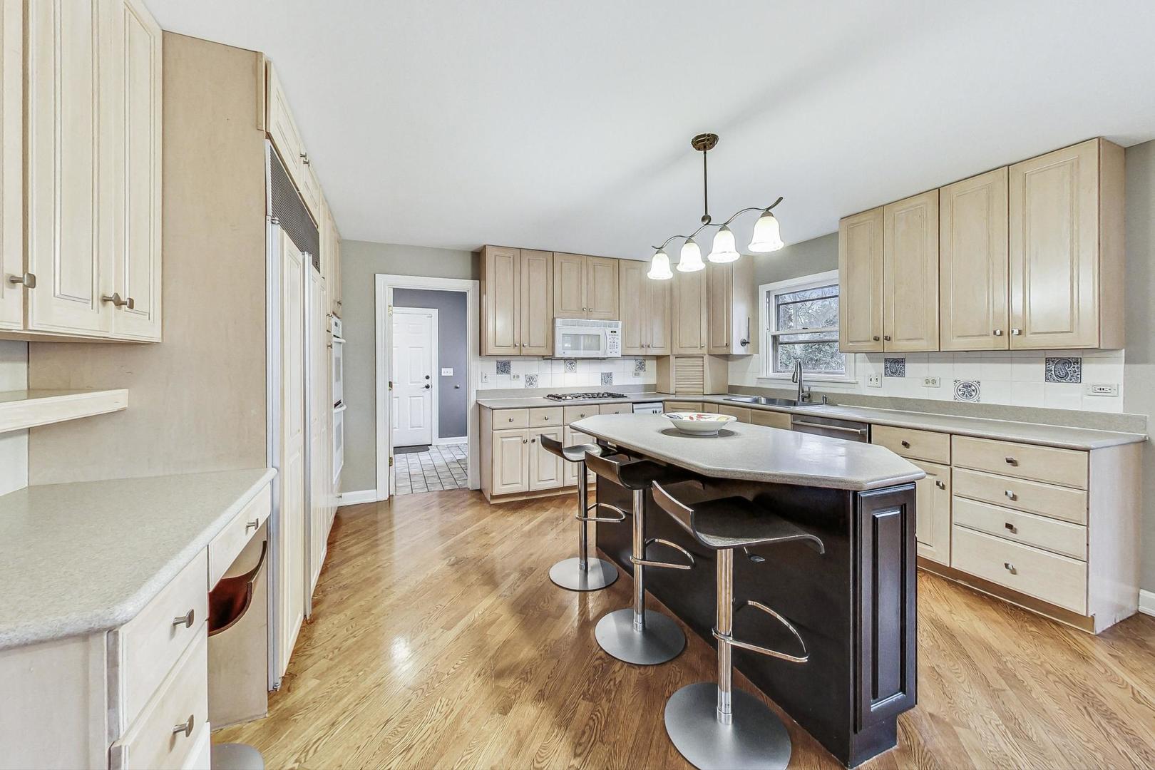 2330 Riverwoods Road Deerfield, IL 60015 - Photo 15 of 50 a kitchen with kitchen island granite countertop a sink cabinets and a counter top space