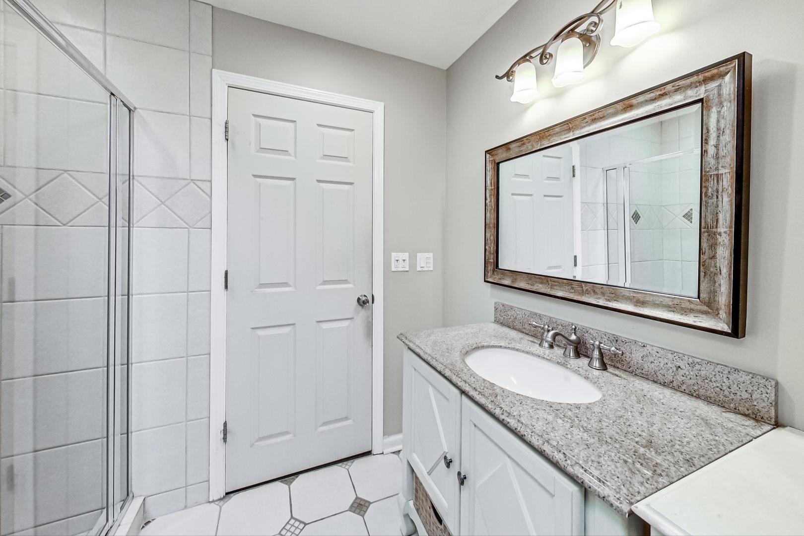 2330 Riverwoods Road Deerfield, IL 60015 - Photo 29 of 50 a bathroom with a granite countertop sink and a mirror