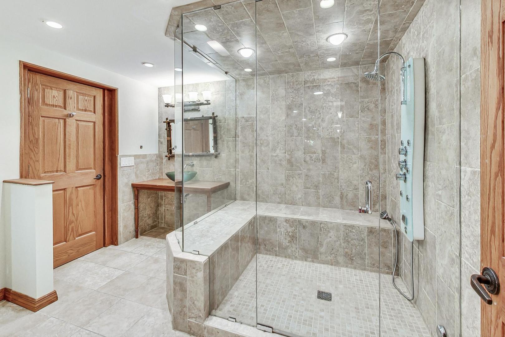 2330 Riverwoods Road Deerfield, IL 60015 - Photo 40 of 50 a bathroom with a granite countertop sink a bathtub and shower