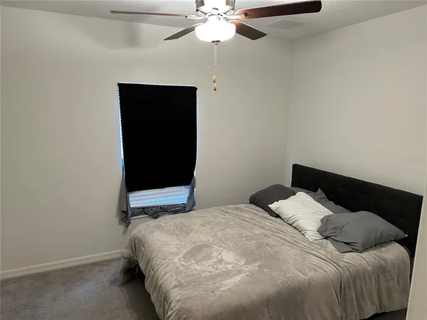 a bedroom with a bed and a ceiling fan