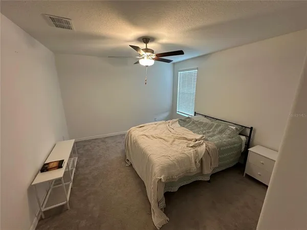 a bedroom with a bed and a ceiling fan