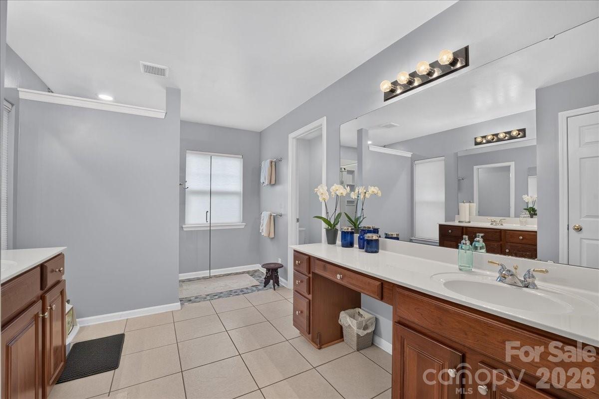 8006 Fine Robe Drive Indian Trail, NC 28079 - Photo 27 of 36 a bathroom with a double vanity sink a mirror and a shower