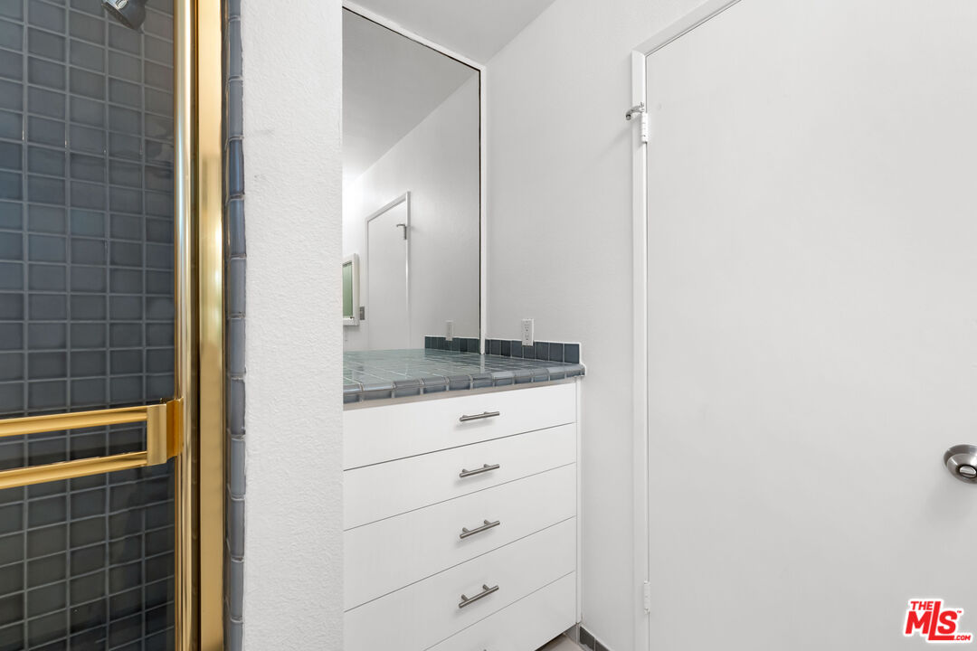 222 7th Street, Unit 301 Santa Monica, CA 90402 - Photo 35 of 55 a bathroom with a granite countertop sink and mirror