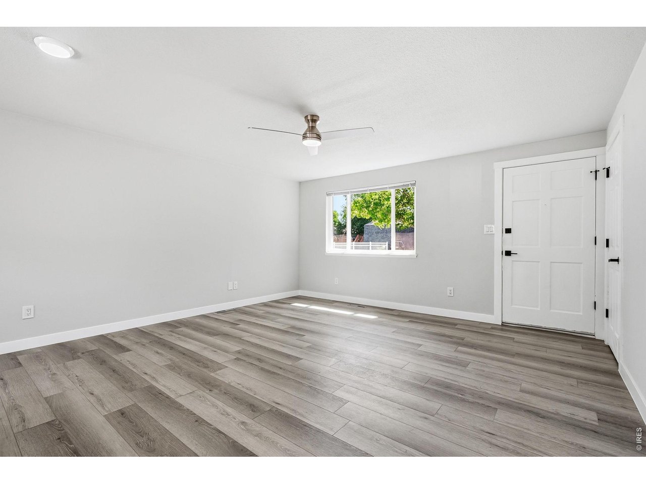 1035 6th Street Berthoud, CO 80513 - Photo 4 of 37 an empty room with wooden floor and windows