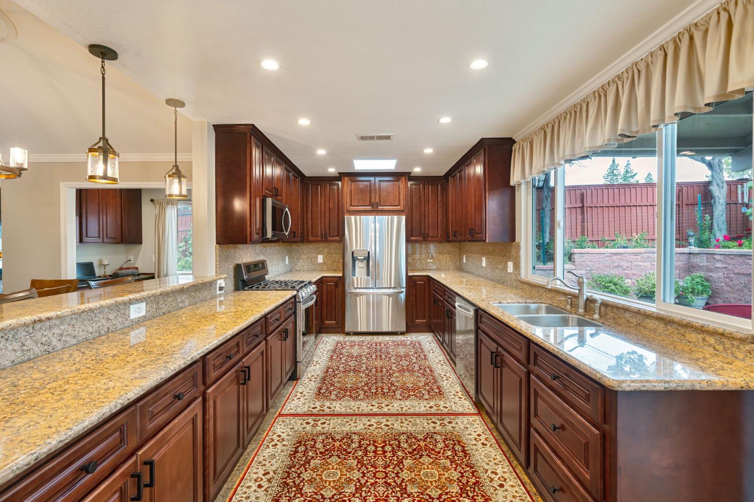 6003 Telesco Way Carmichael, CA 95608 - Photo 14 of 47 a large kitchen with stainless steel appliances granite countertop a stove a sink and a wooden cabinets