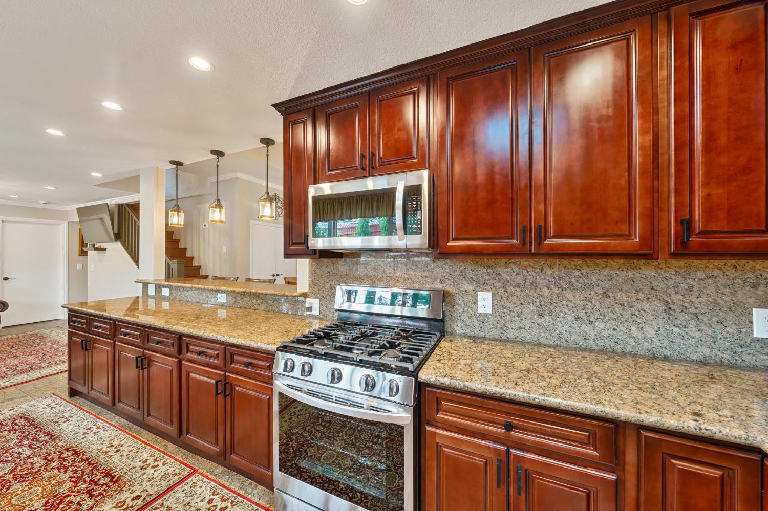 6003 Telesco Way Carmichael, CA 95608 - Photo 17 of 47 a kitchen with stainless steel appliances granite countertop wooden cabinets and a stove top oven