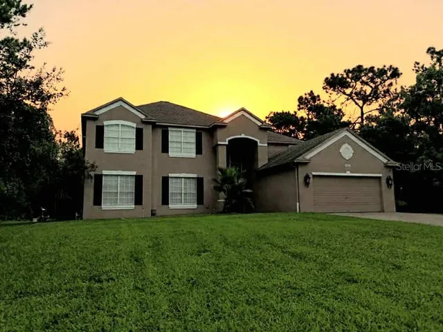 a front view of a house with a yard and trees