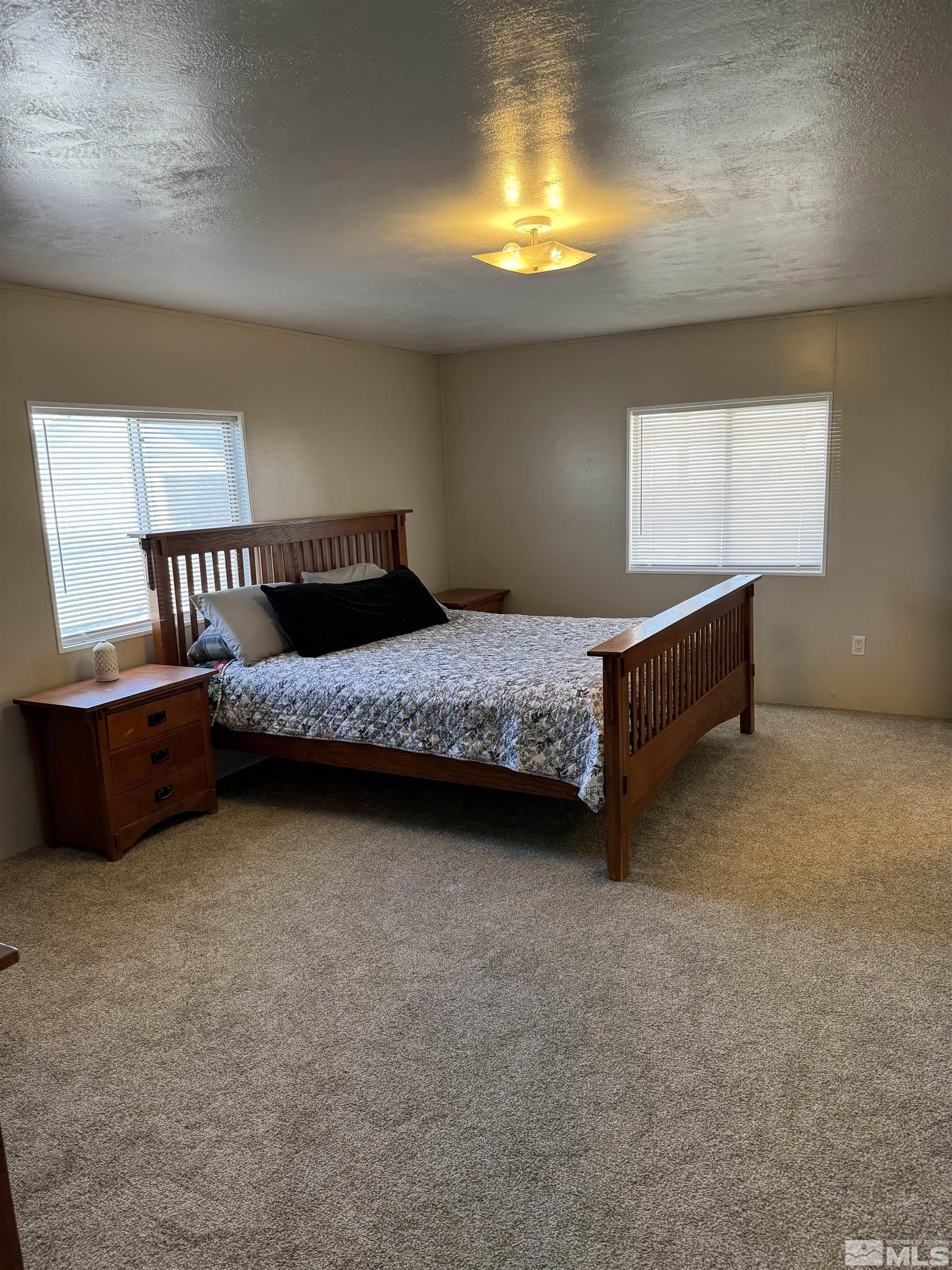 5500 Mission Road Fallon, NV 89406 - Photo 6 of 15 a bedroom with a bed and a lamp