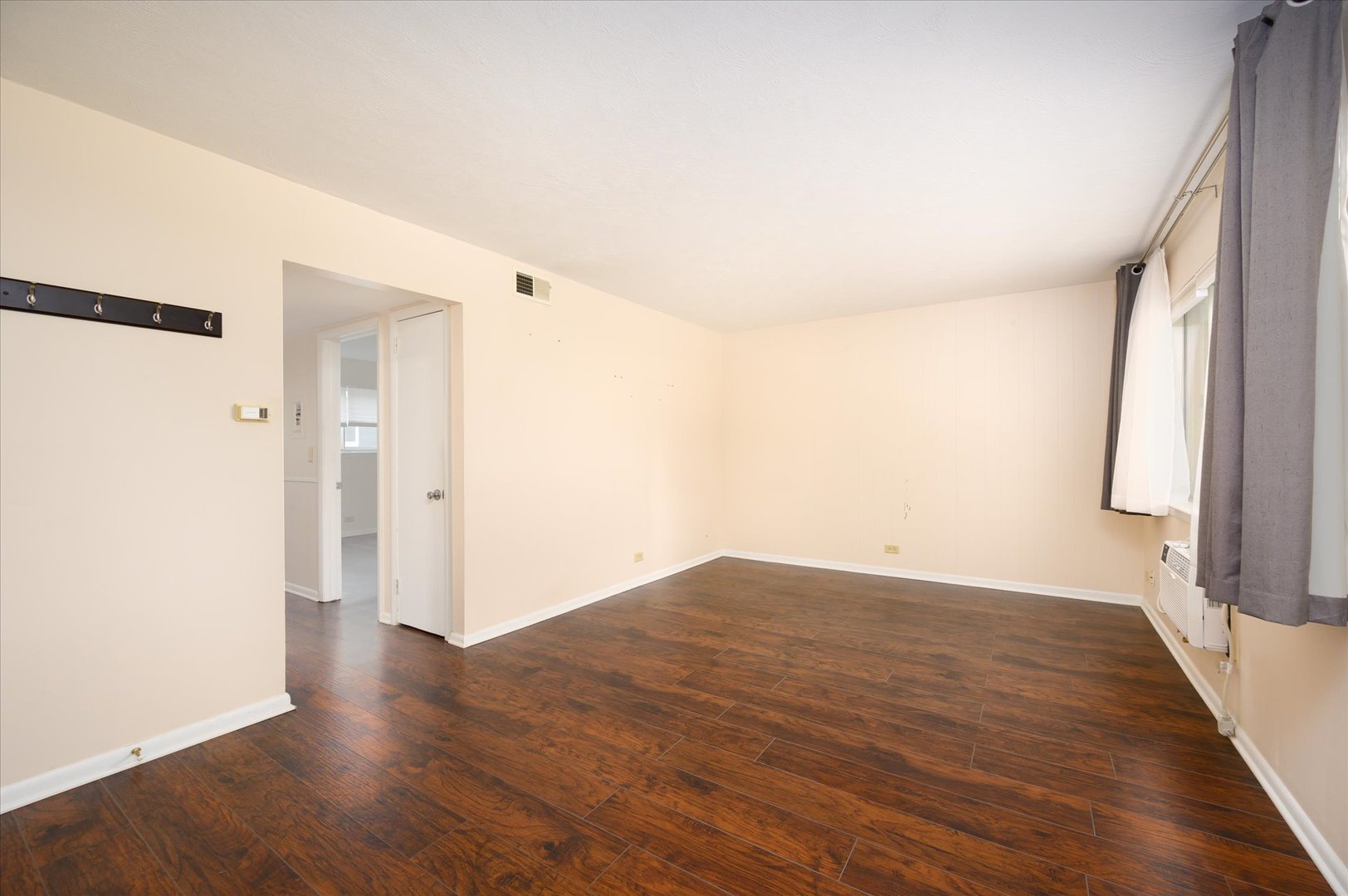 235 East Palatine Road, Unit 1C Palatine, IL 60067 - Photo 4 of 13 a view of an empty room with wooden floor and a window