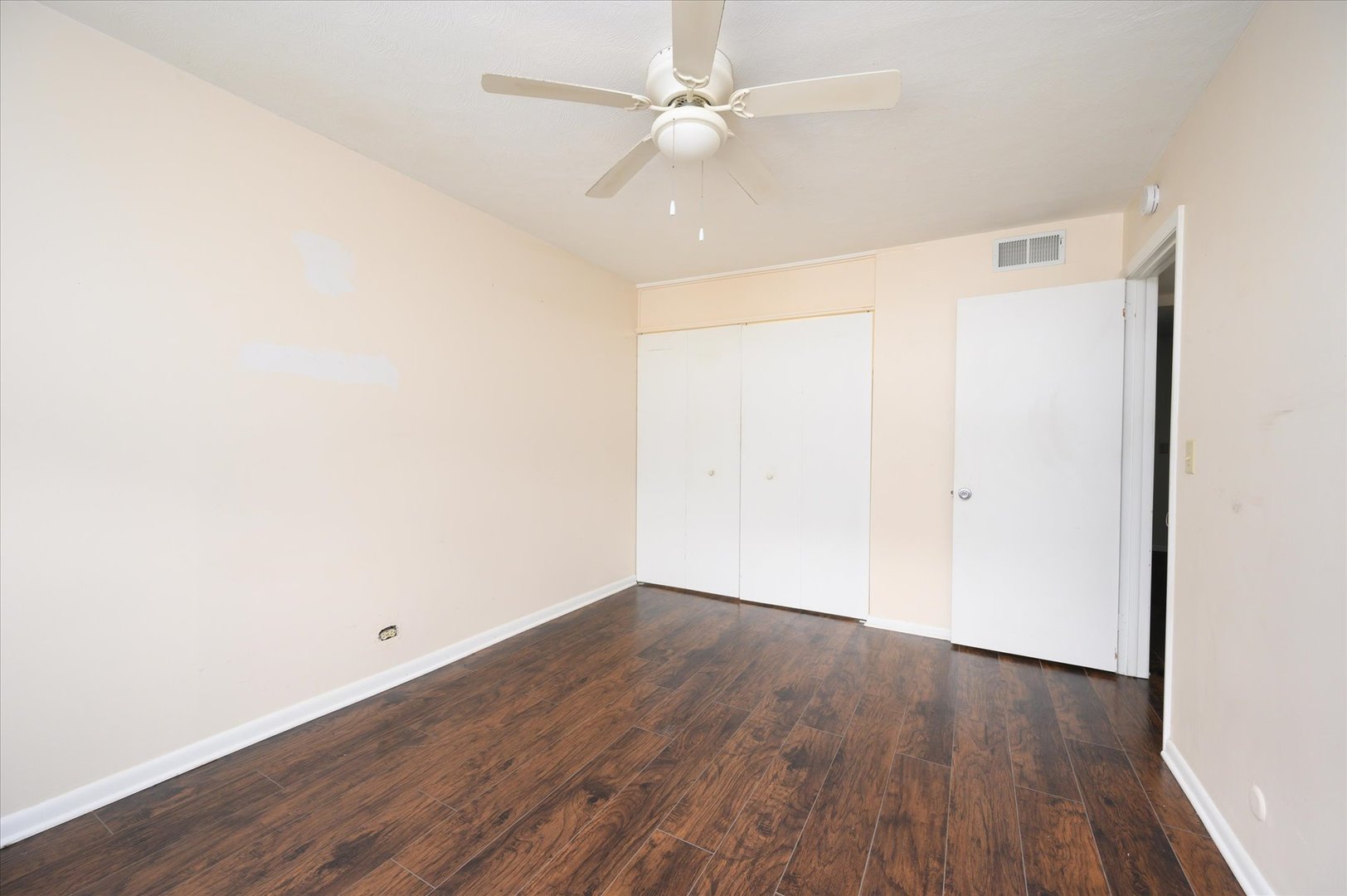 235 East Palatine Road, Unit 1C Palatine, IL 60067 - Photo 9 of 13 an empty room with wooden floor and fan