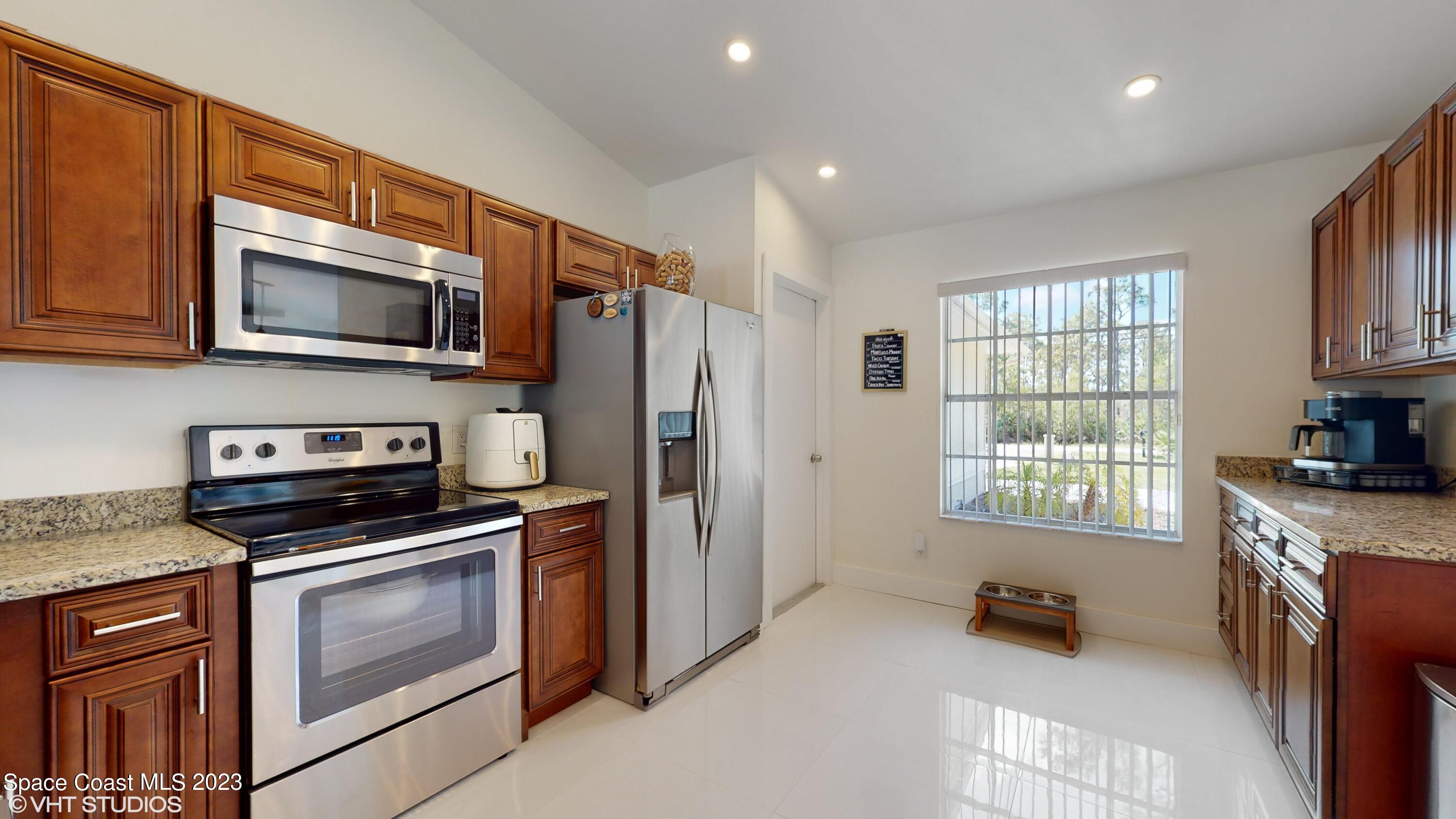 1650 Benjamin Road Malabar, FL 32950 - Photo 12 of 34 a kitchen with stainless steel appliances a stove sink microwave and cabinets