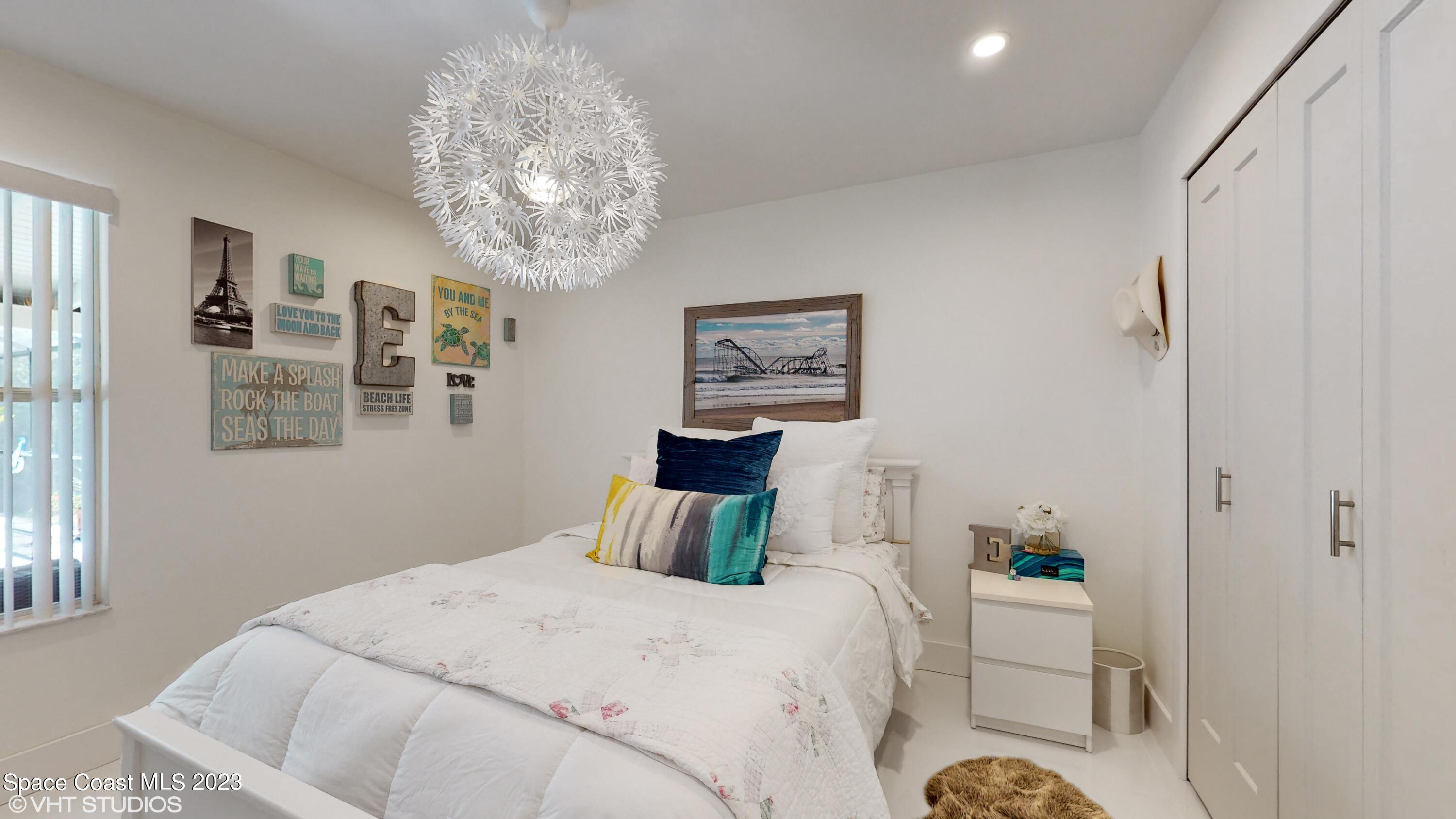 1650 Benjamin Road Malabar, FL 32950 - Photo 23 of 34 a bedroom with a bed and a chandelier