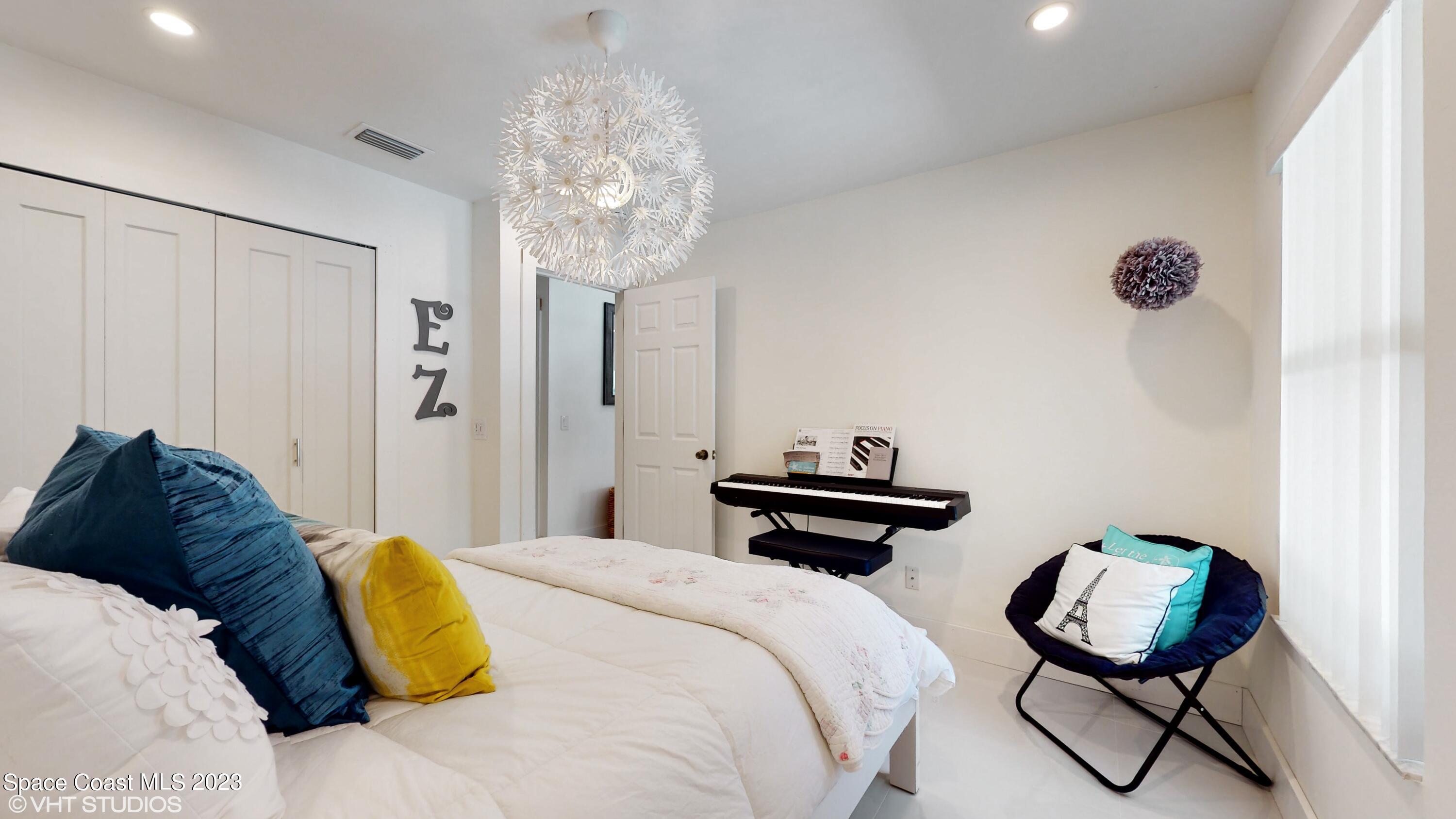 1650 Benjamin Road Malabar, FL 32950 - Photo 24 of 34 a bedroom with a bed and a chandelier