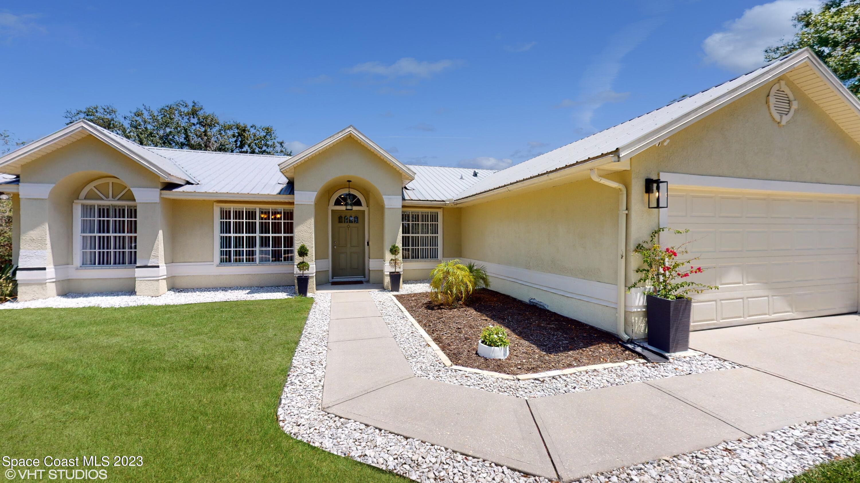 1650 Benjamin Road Malabar, FL 32950 - Photo 3 of 34 a front view of a house with garden