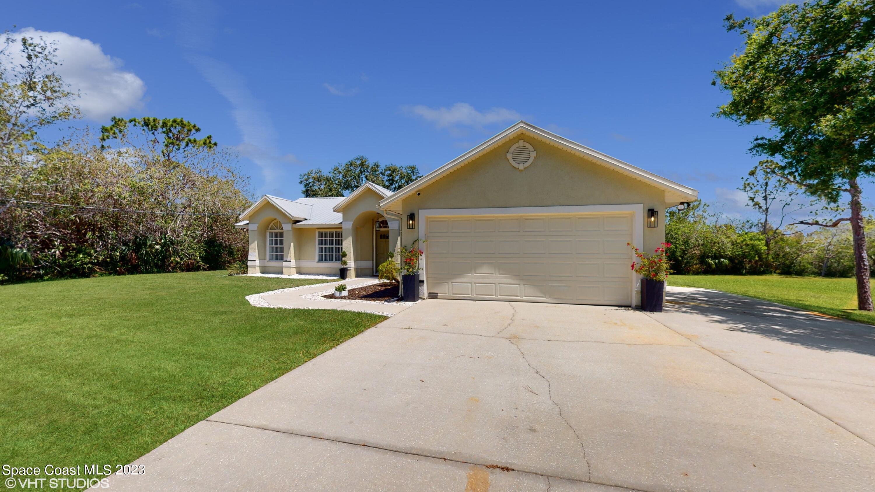 1650 Benjamin Road Malabar, FL 32950 - Photo 4 of 34 a front view of a house with garden